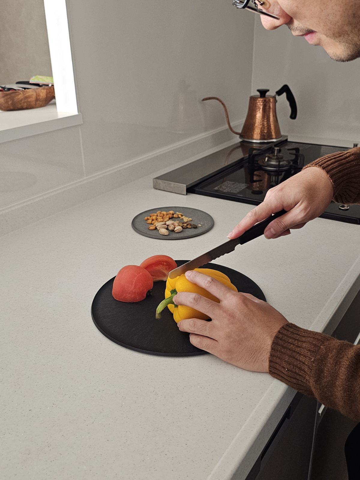 A male staff member using a CHOPLATE for meal prep, highlighting its practical use for daily cooking.