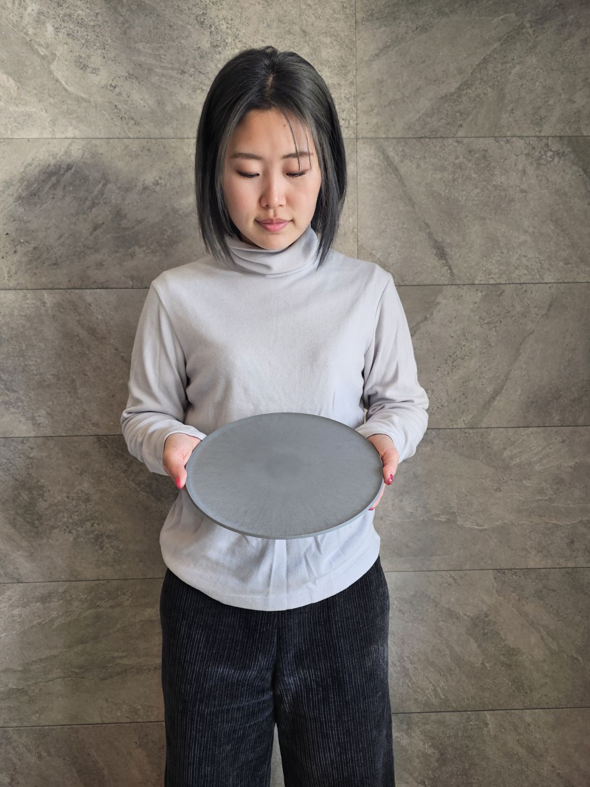A female staff member at SANTAKA holding a CHOPLATE to show how lightweight and easy it is to handle.